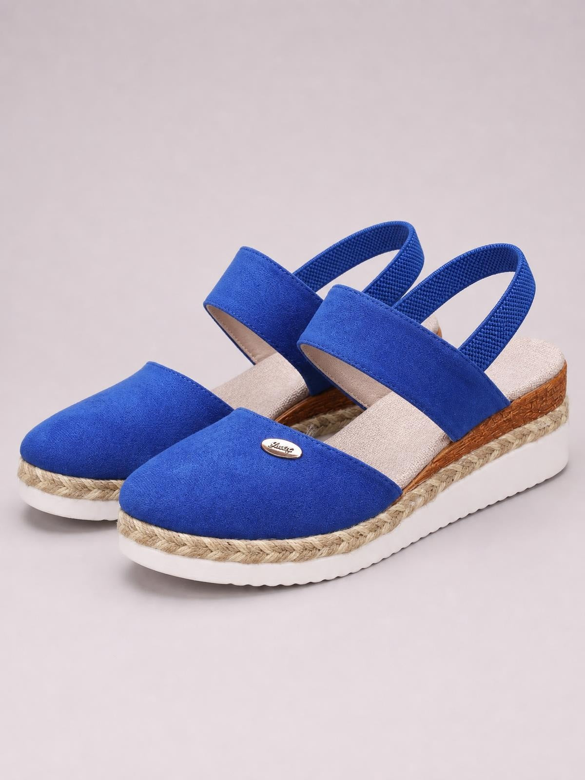 Bright blue canvas round toe wedge sandals feature wide front straps, elastic slingback bands, braided espadrille trim, and chunky white rubber soles.