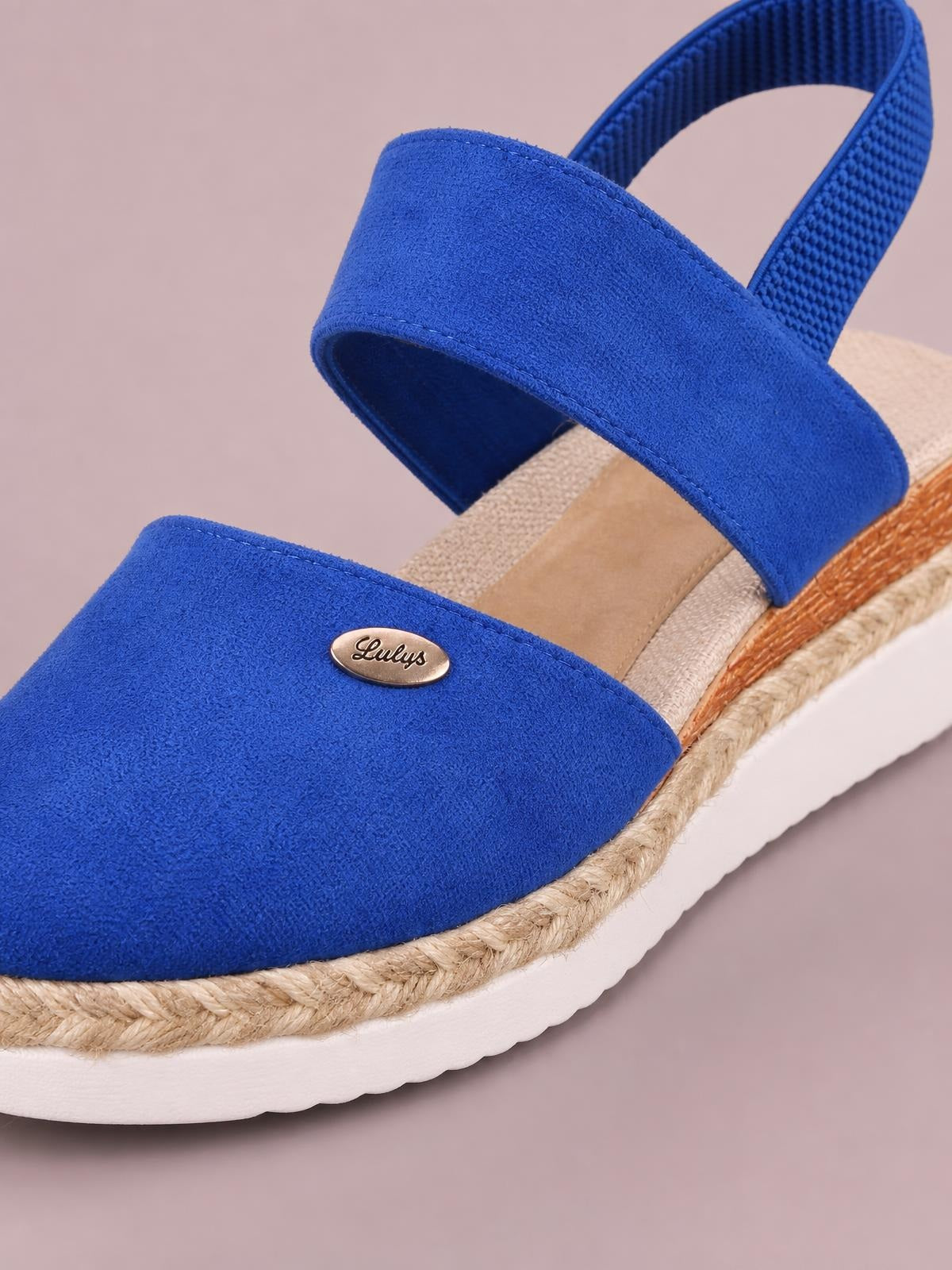 Bright blue canvas round-toe wedge sandals feature broad crossover straps, ankle straps, woven espadrille-style midsoles, and white rubber platform outsoles.