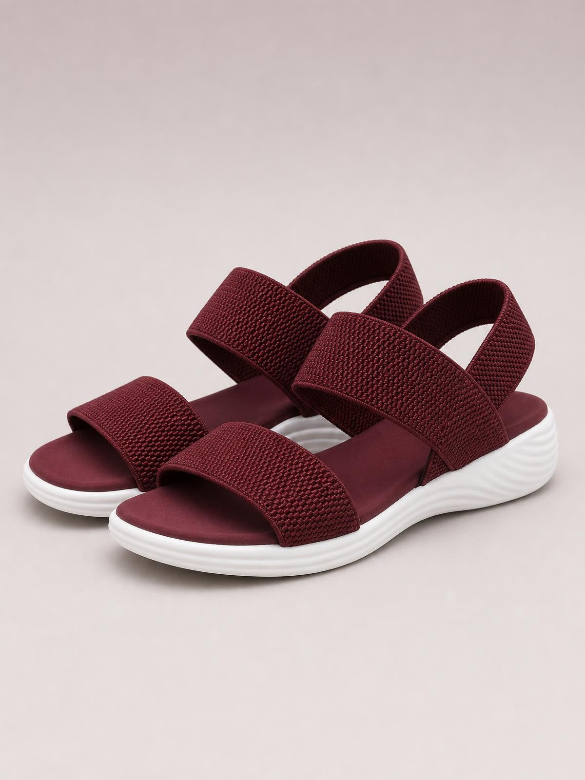 Burgundy rubber open-toe sandals with wide textured crossover straps, ankle straps, cushioned footbeds, and chunky low white heels.