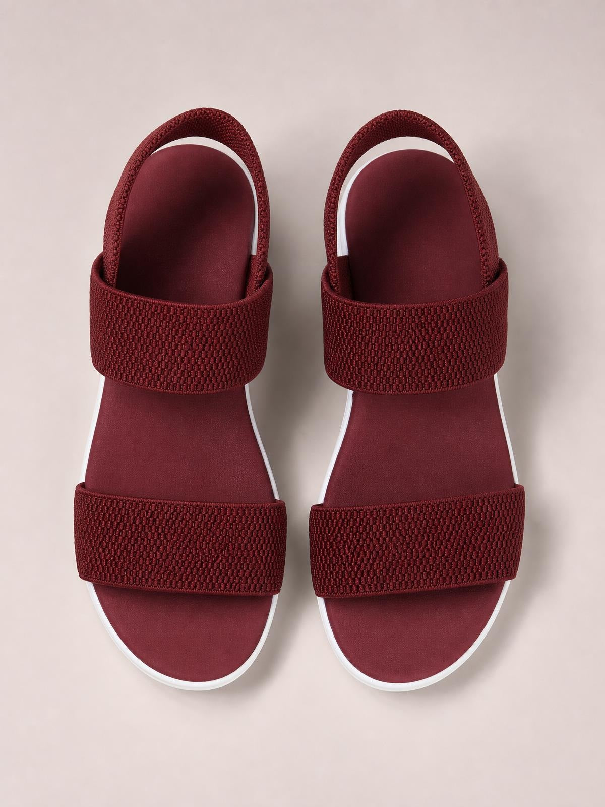 Burgundy rubber open toe low heel sandals with textured wide straps, ankle straps, cushioned footbeds, and contrasting white sole edges.