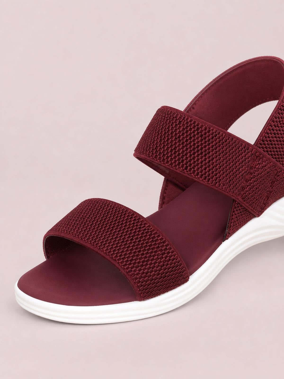 Burgundy open-toe low-heel sandals feature textured wide straps, a supportive back strap, and a contrasting white rubber sole.