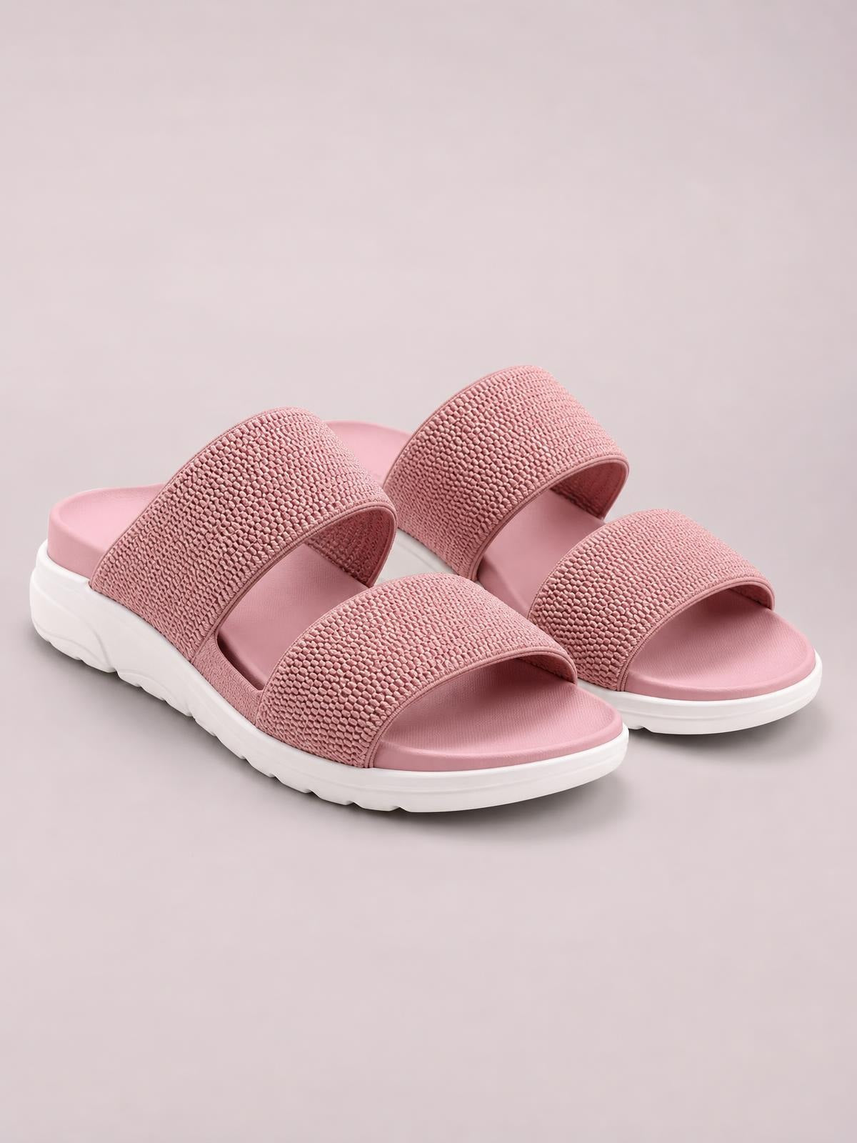 Pink rubber open-toe low-heel sandals with two textured wide straps, cushioned footbeds, and chunky white lugged soles.