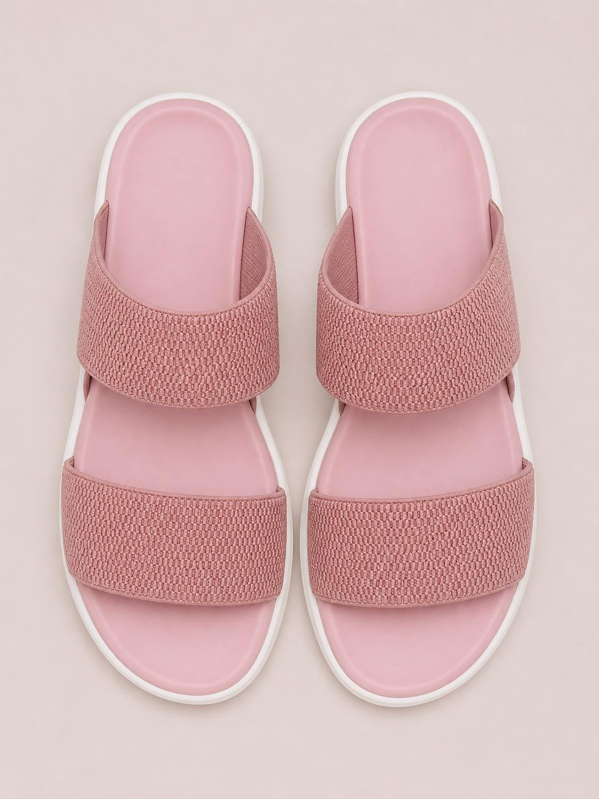Pink rubber open-toe low heel sandals with cushioned footbeds, white soles, and two wide textured crossover straps for a secure fit.