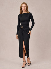 Model in a black ruched slit long-sleeve bodycon dress with a fitted silhouette, gathered waist, decorative button, and ankle-length hem.