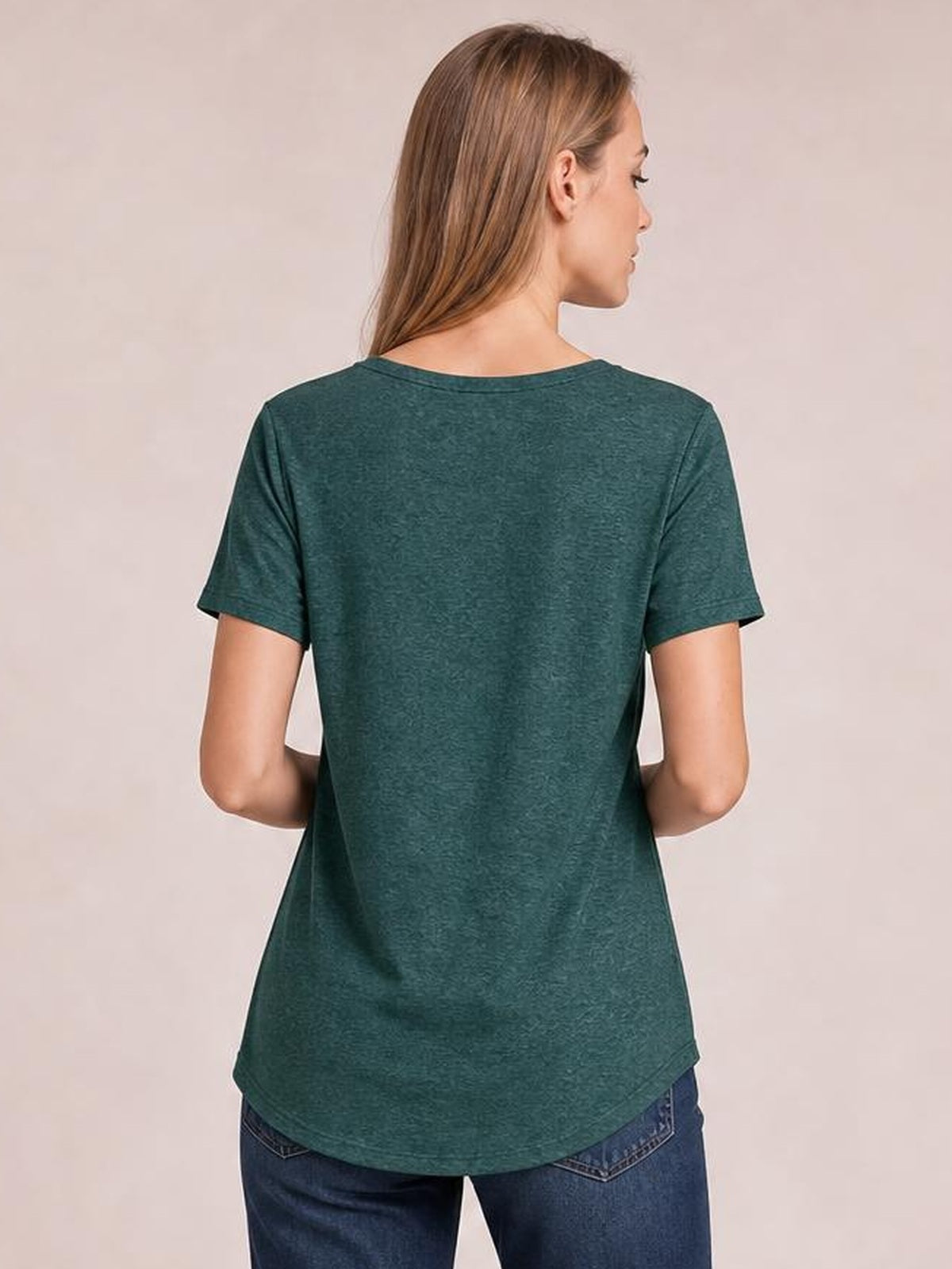 Model shown from the back in a dark teal short-sleeve T-shirt with a relaxed silhouette, curved hem, and softly draped opaque construction.