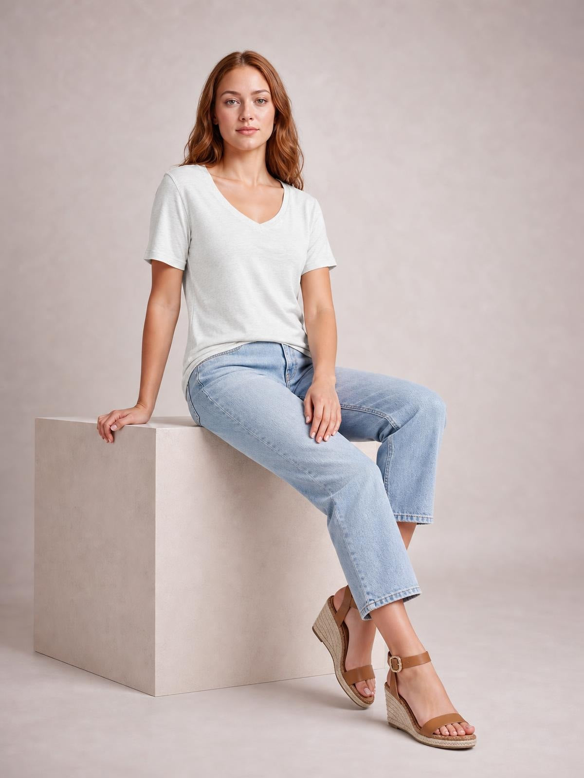 A seated model wears a light gray ruched V-neck short-sleeve T-shirt with a relaxed, slightly stretchy silhouette and simple construction.