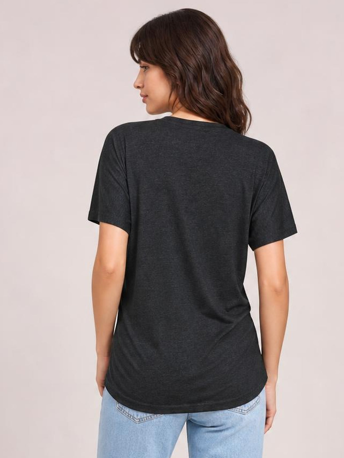 Model shown from the back in a charcoal short sleeve T-shirt with a relaxed, gently curved hem and softly draped stretch silhouette.