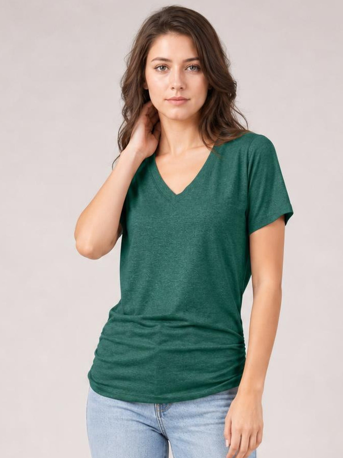 Model wearing a forest green ruched V-neck short sleeve T-shirt with a relaxed silhouette and gathered ruching along the lower hem.