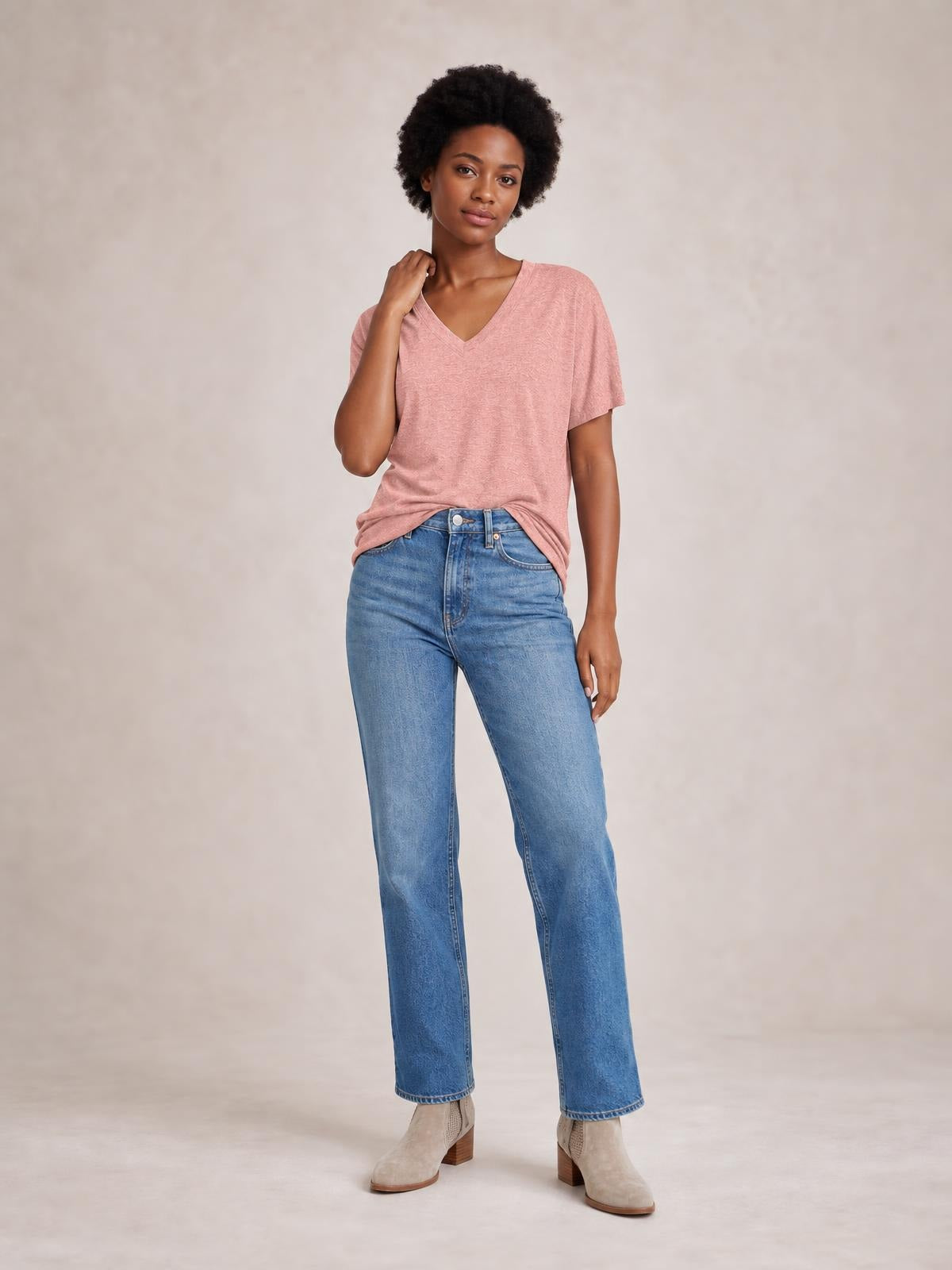 Model wearing a soft pink ruched V-neck short-sleeve T-shirt with a relaxed, stretchy silhouette and visible gathering at the hem.