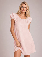 Model poses in a watermelon pink mini dress with a relaxed silhouette, rounded neckline, fluttery ruffle sleeves, and a softly curved hem.