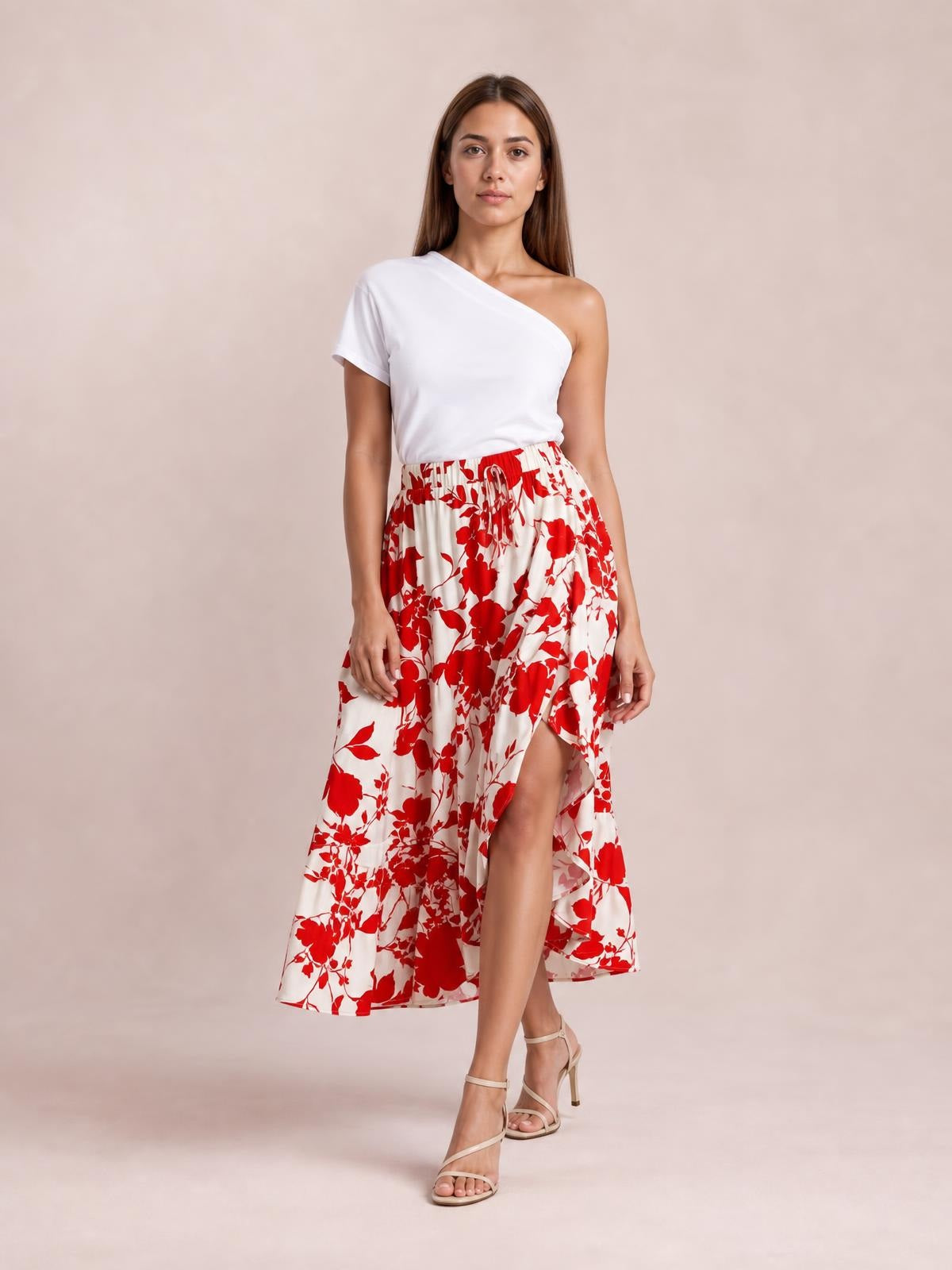 Model poses in a white and red floral printed midi skirt with a flowy silhouette, gathered waistband, and layered ruffled hem.