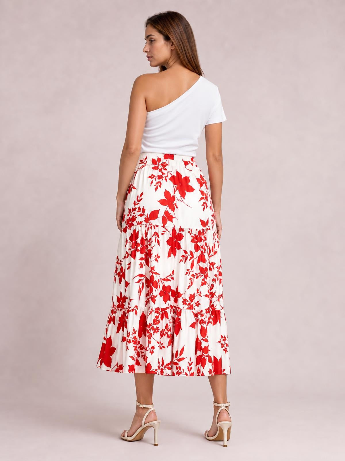 Model shown from behind wearing a white and red floral printed midi skirt with a high waist, tiered construction, and flowy ruffled hem.