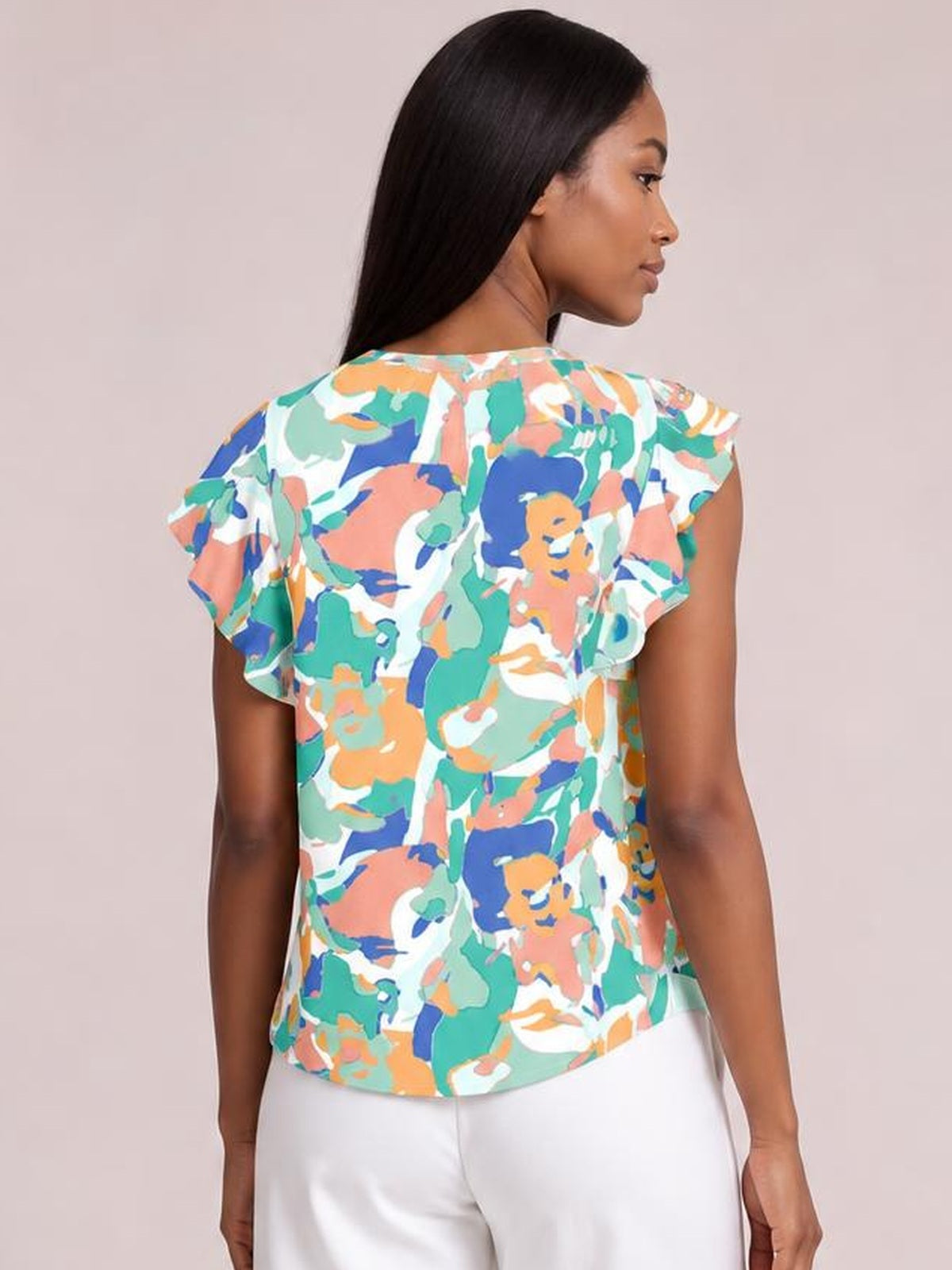 Model turned away showcases a colorful abstract printed blouse with ruffled cap sleeves, a notched neckline, and a relaxed straight silhouette.