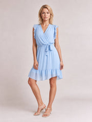 Model in a light blue ruffled surplice cap sleeve dress with a tied waist, softly gathered A-line skirt, and tiered ruffle hem.