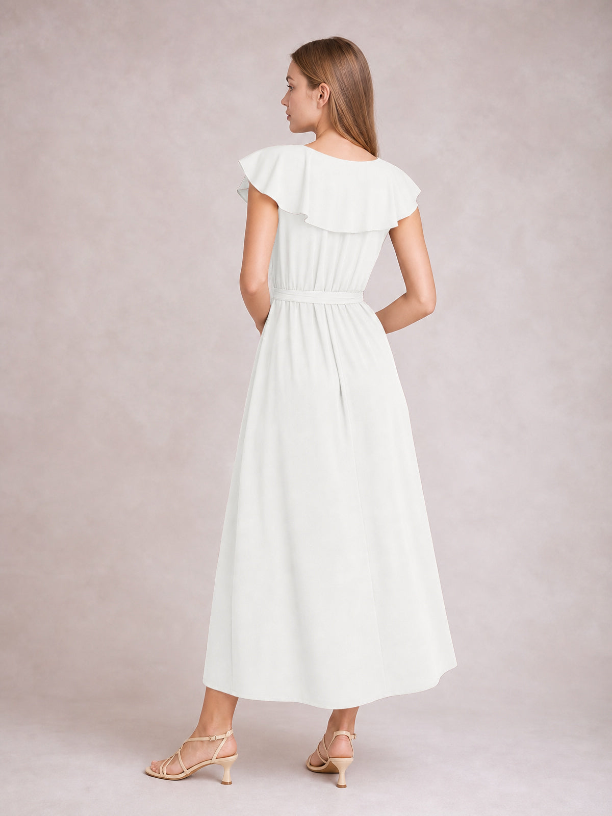 A model stands turned away in a white ruffled midi dress with flutter sleeves, a defined tie waist, gathered bodice, and flowing A-line skirt.