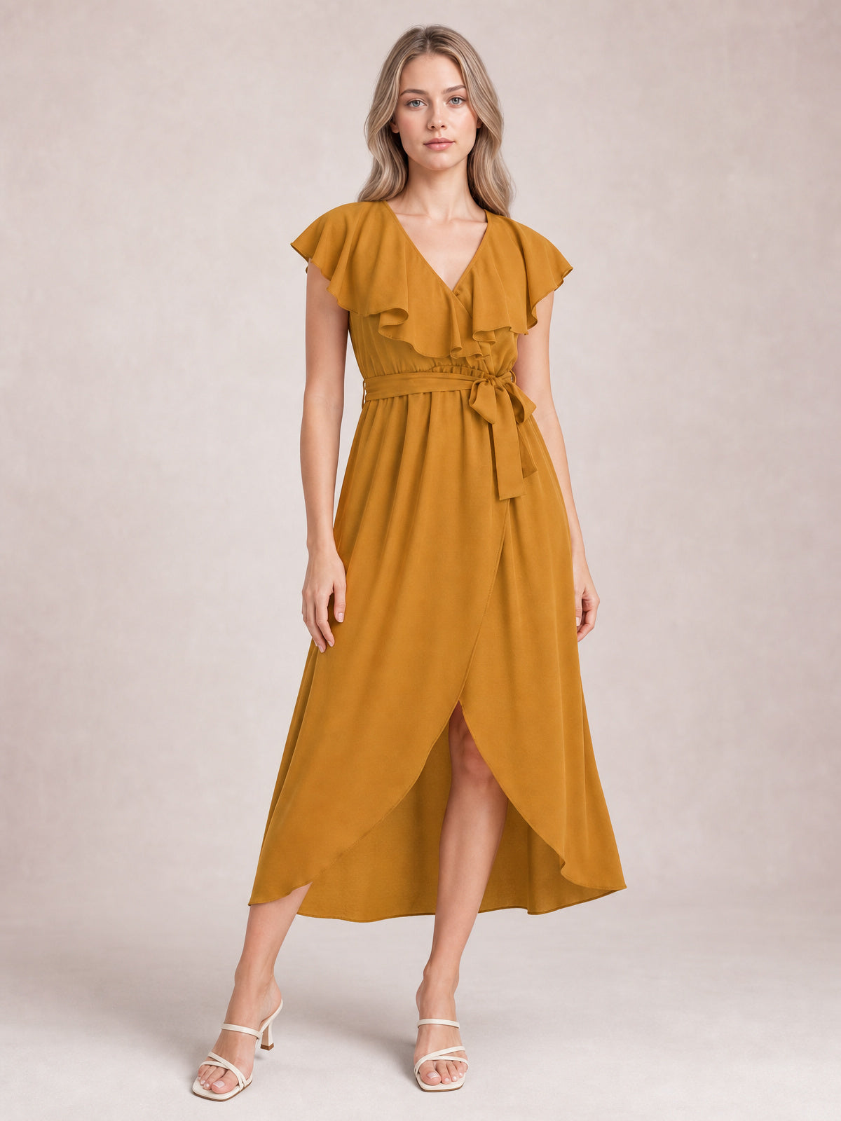Model stands in a mustard ruffled surplice midi dress with flutter sleeves, a tied waist, flowing wrap-style skirt, and front leg-baring slit.
