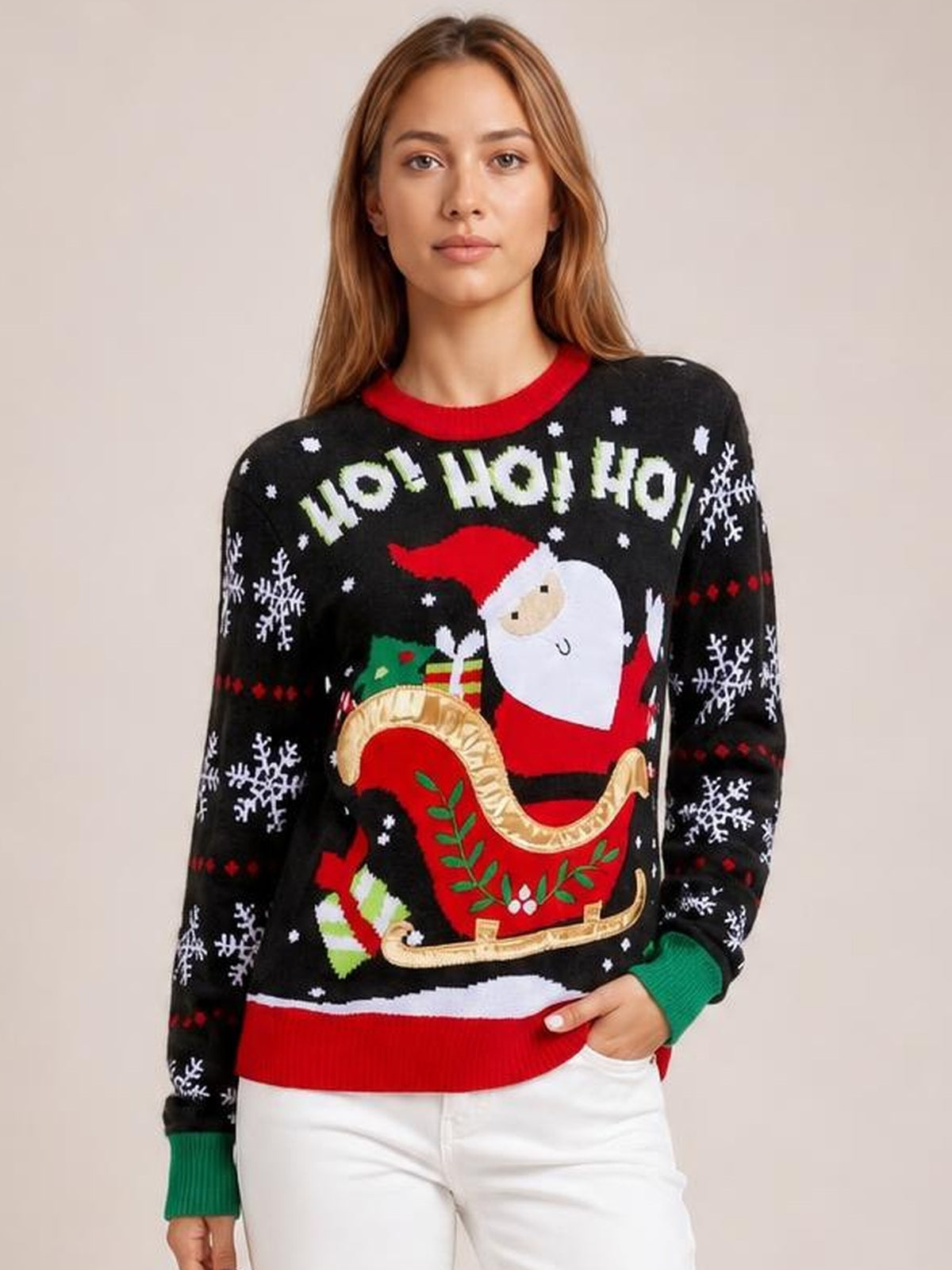 A woman models a black Santa graphic round neck long sleeve sweater with a relaxed silhouette, snowflake motifs, and red and green ribbed cuffs and hem.