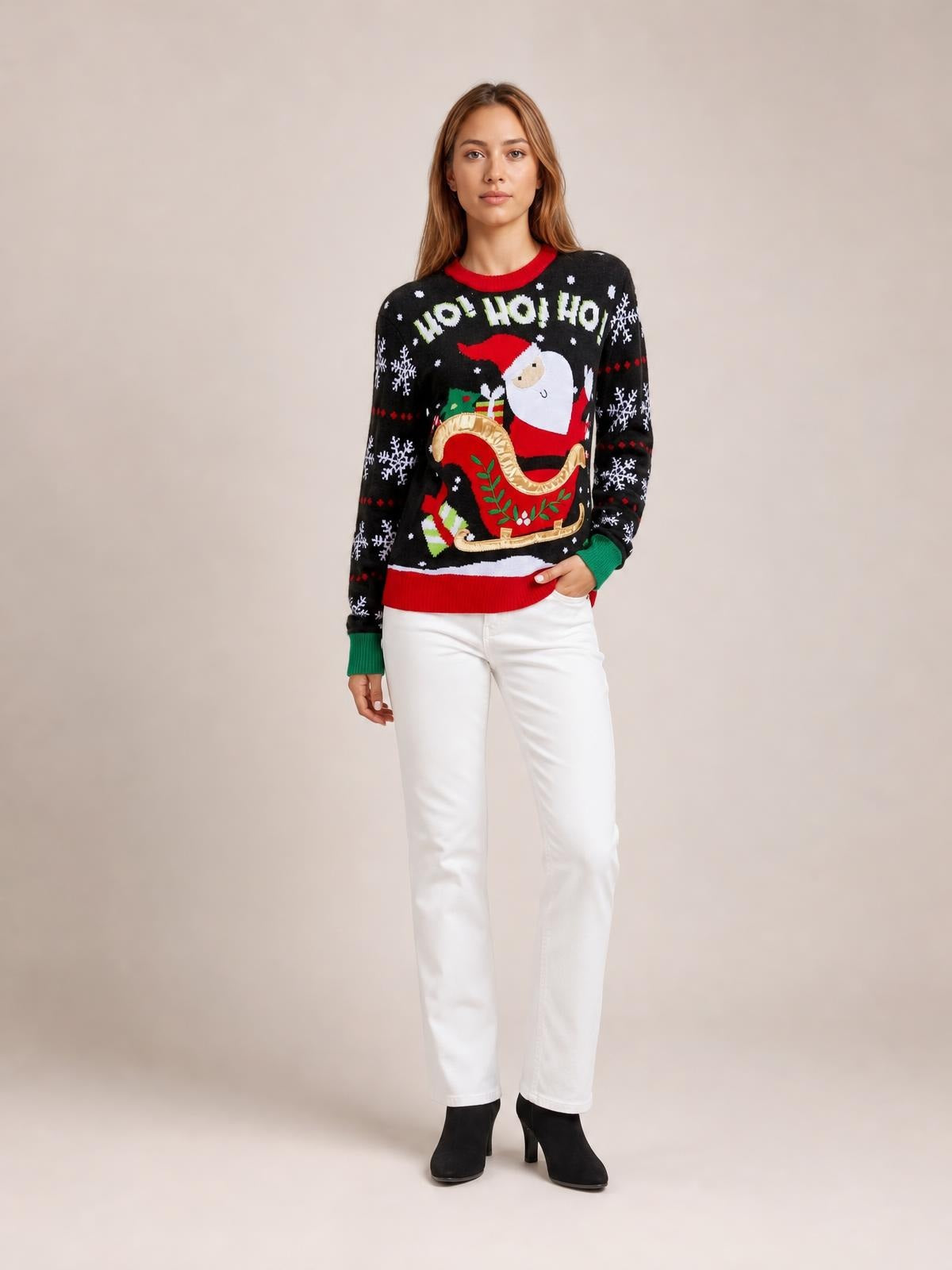A model stands with one hand in her pocket wearing a black Santa graphic round-neck long-sleeve sweater with red and green trim and a relaxed silhouette.