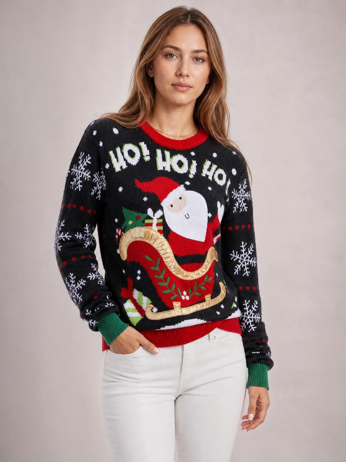 A model wears a black Santa graphic round-neck long-sleeve sweater with a relaxed silhouette, red ribbed trim, green cuffs, snowflakes, and a festive sleigh design.