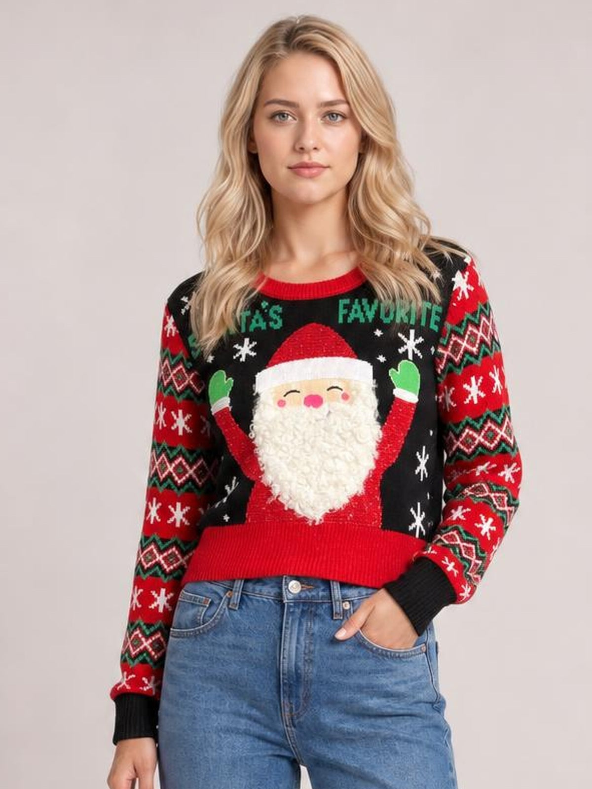Model wears a black SANTA’S FAVORITE graphic long sleeve sweater with a Santa design, red ribbed trim, festive patterned sleeves, and a relaxed silhouette.