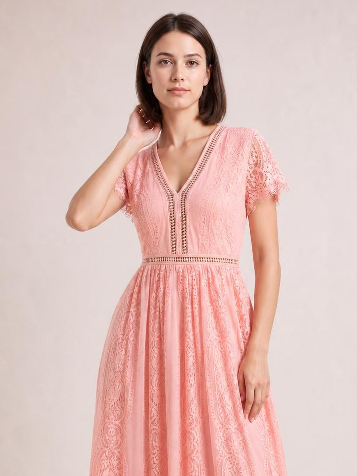 A model poses in a pink lace plunge maxi dress with a V-neck, short scalloped-trim sleeves, defined waist, and softly flared silhouette.