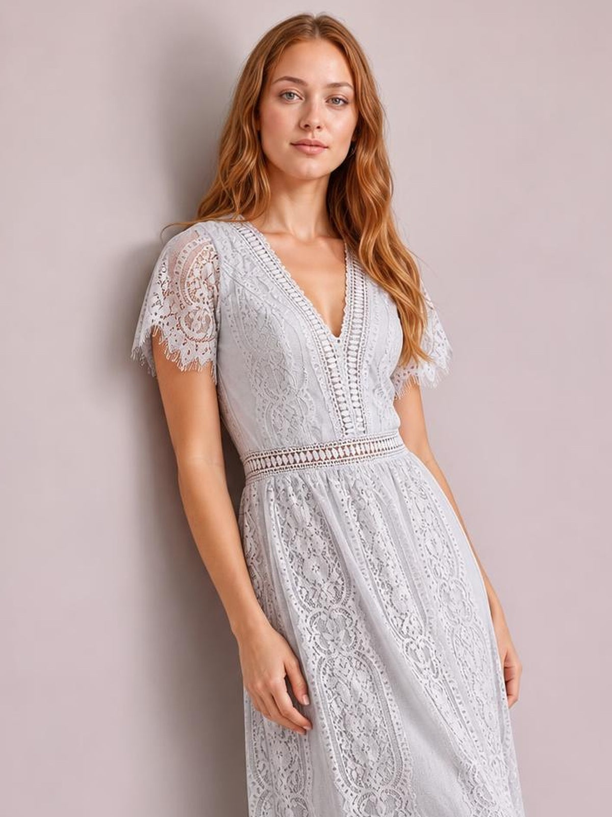 Model poses in a light gray lace maxi dress with a plunging V-neck, scalloped short sleeves, fitted waist, and flowing paneled skirt.