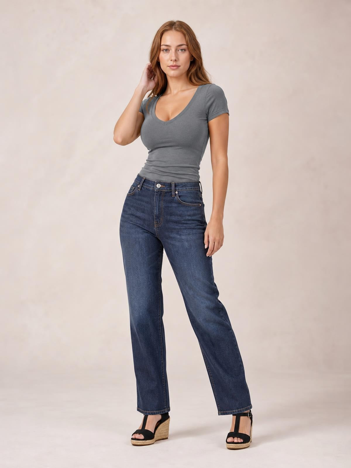 Model poses in a fitted gray scoop neck short sleeve T-shirt with a slightly stretchy silhouette, short sleeves, and a clean basic construction.