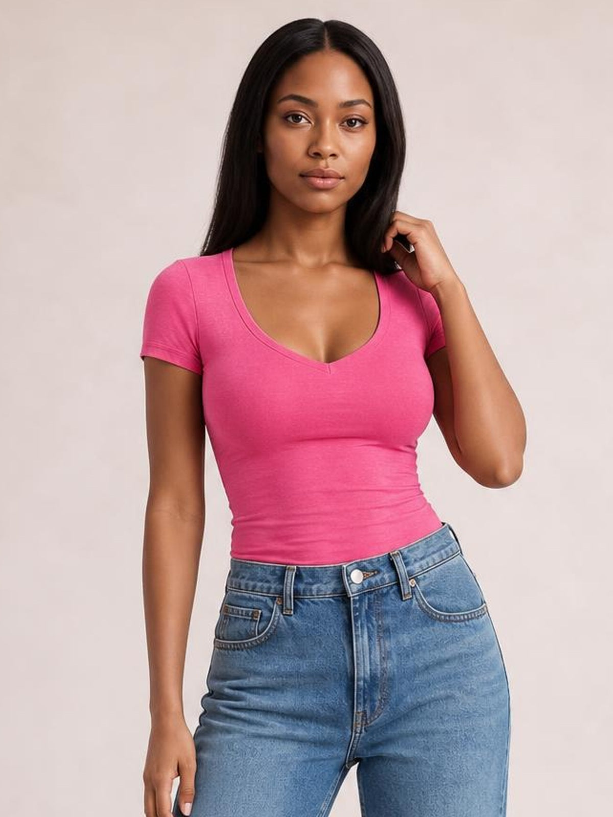 Model poses in a bright pink scoop neck short sleeve T-shirt with a fitted silhouette, smooth construction, and slight stretch.