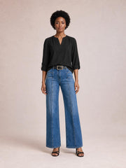 Model stands facing forward in blue shift jeans with a wide-leg silhouette, front seam detailing, belt loops, and front pockets.