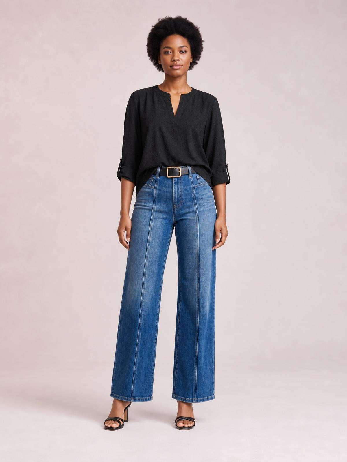 Model stands facing forward in blue seam detail shift jeans with a high waist, front pockets, and a relaxed wide-leg silhouette.