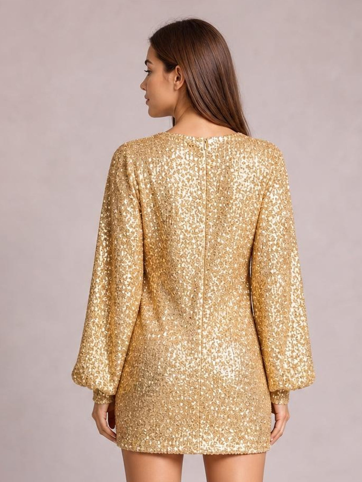 Model shown from the back in a gold sequin long sleeve ruched mini dress with a straight silhouette, lined construction, and center-back zipper.
