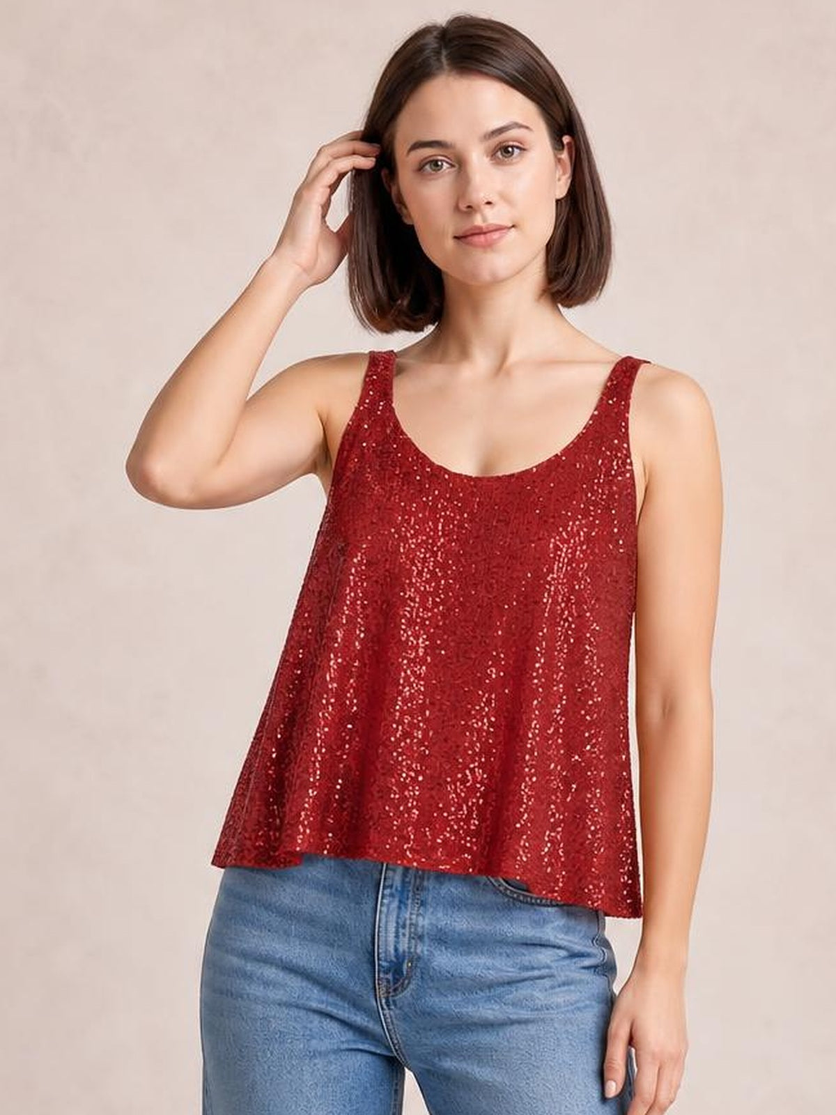 Model poses with one hand in her hair, wearing a red sequin scoop neck tank with wide straps and a loose, slightly flared silhouette.
