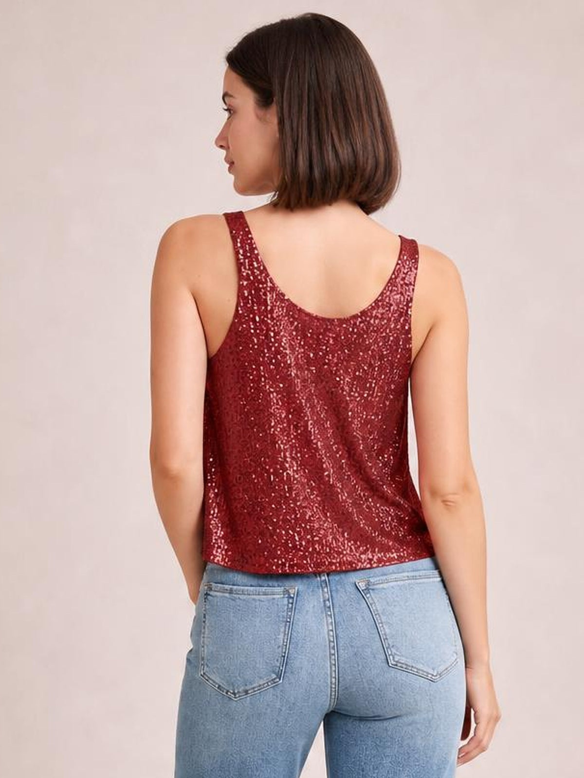 Model shown from the back in a burgundy sequin scoop neck tank with wide shoulder straps, relaxed straight silhouette, and shimmery finish.