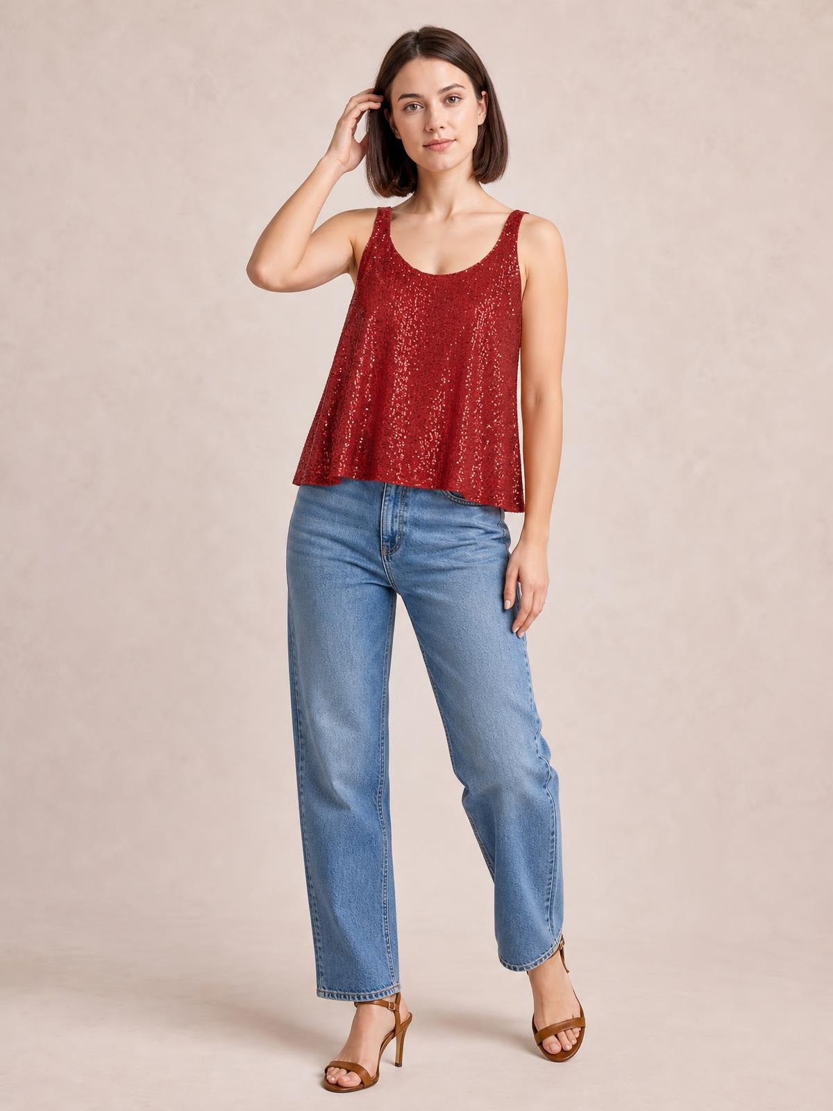 Model poses in a red sequin scoop neck tank with wide straps and a relaxed, slightly flared silhouette.