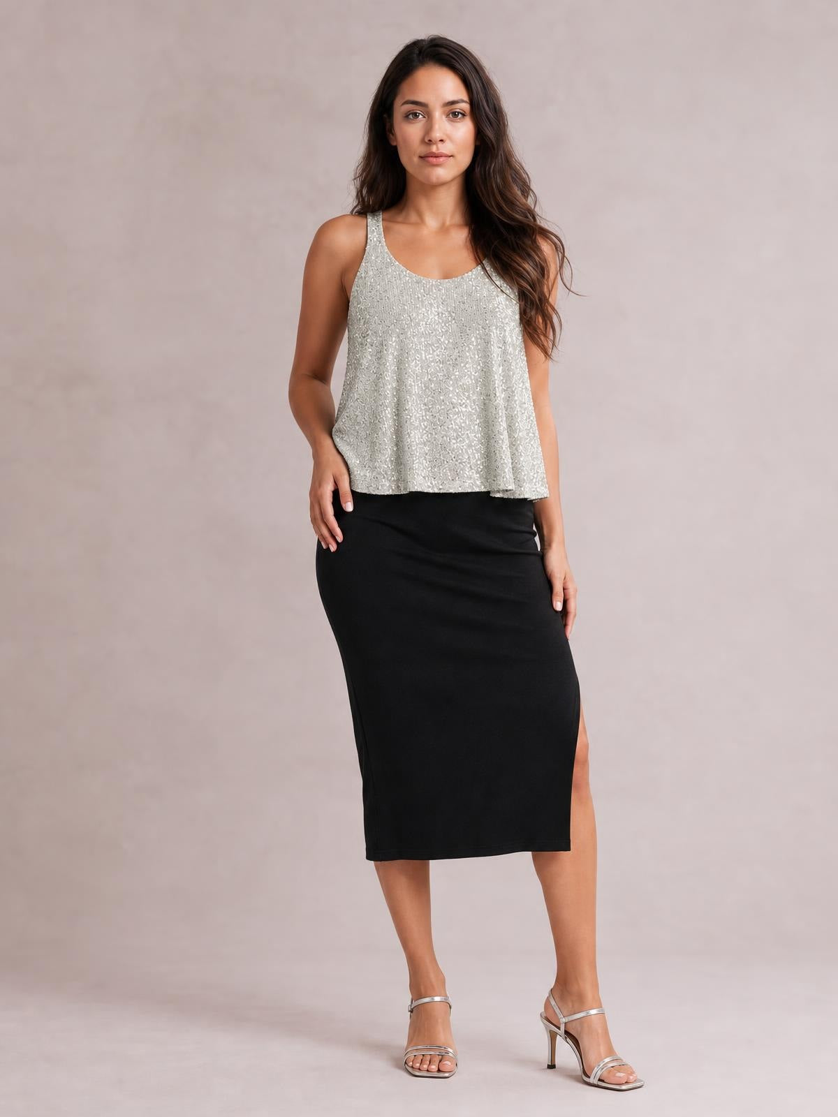 A model wears a silver sequin scoop neck tank with wide shoulder straps, a sleeveless design, relaxed straight silhouette, and softly flared hem.