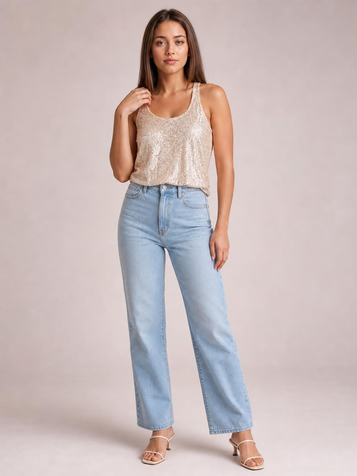 Model poses in a shimmery ivory sequin tank with a scoop neckline, wide shoulder straps, and a relaxed straight silhouette.
