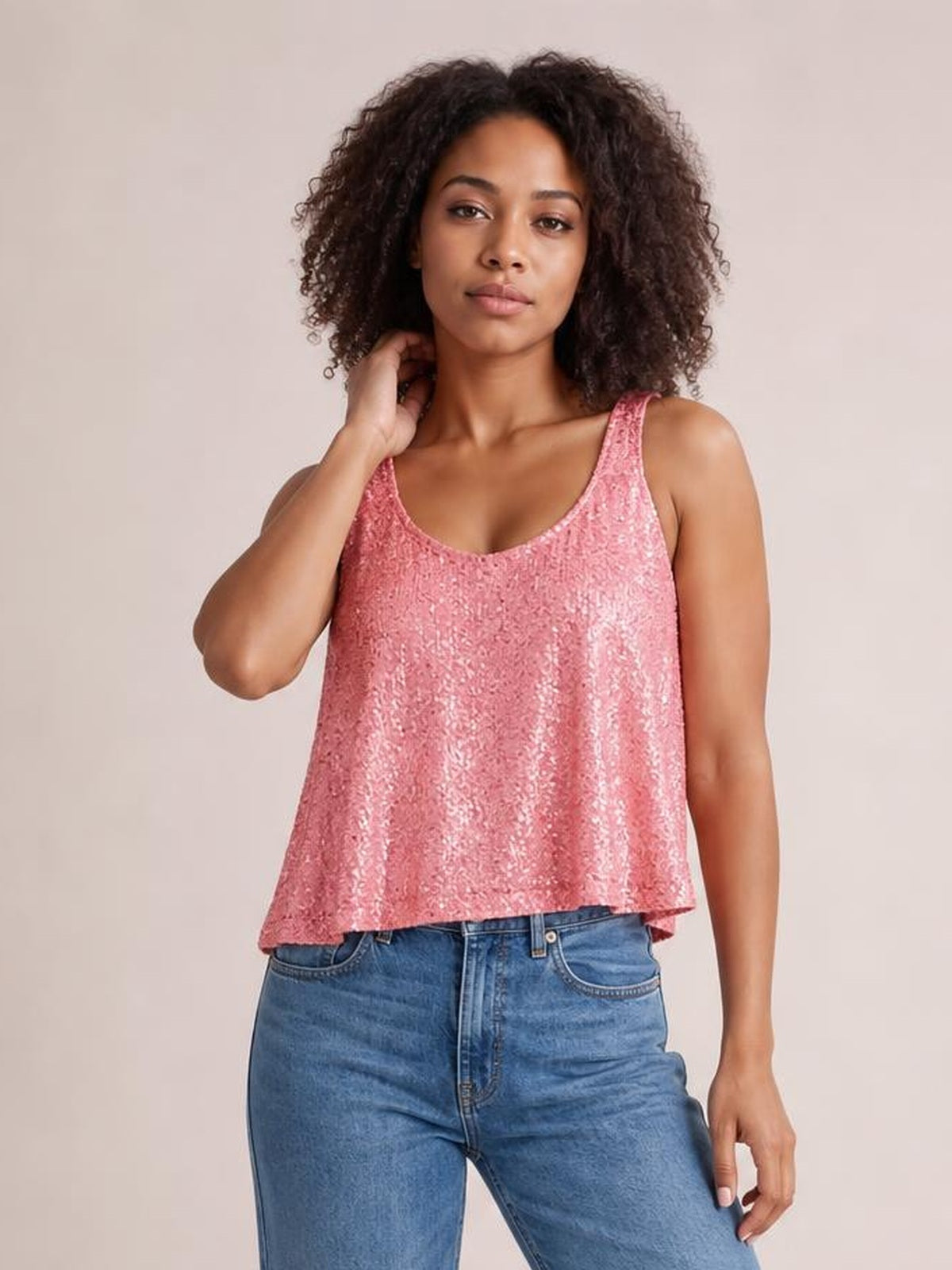 Model poses in a pink sequin scoop neck tank with wide straps, a relaxed A-line silhouette, and a slightly flared hem.