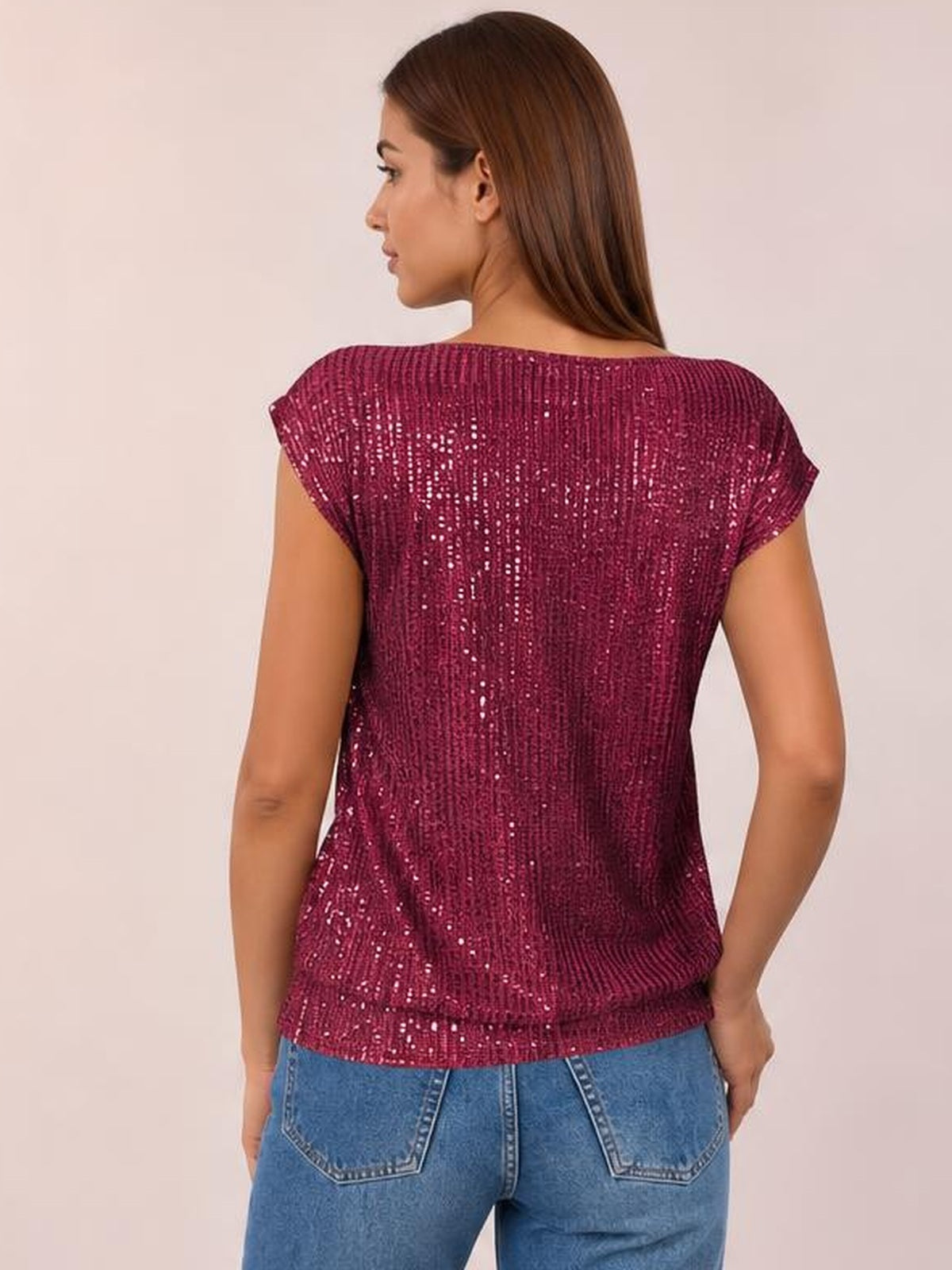 Back view of a model wearing a burgundy sequin top with cap sleeves, a relaxed straight silhouette, and a softly curved hem.