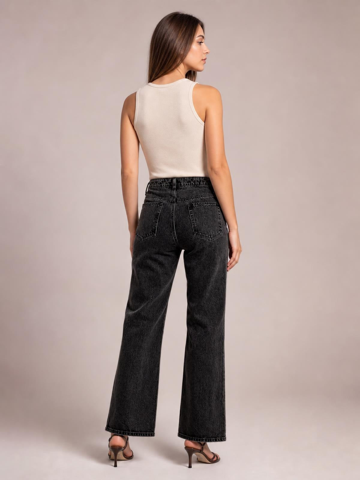 Model shown from behind wears black wide-leg jeans with a structured waistband, belt loops, back patch pockets, and full-length hems.