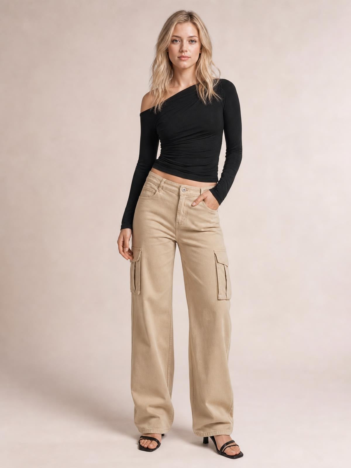Model poses in a fitted black single-shoulder long-sleeve T-shirt with a ruched bodice and cropped silhouette.