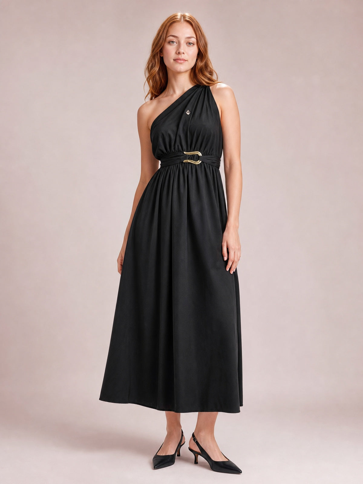 Model poses in a black single shoulder midi dress with gathered bodice, defined waist, ring-detail belt, and flowing A-line skirt.