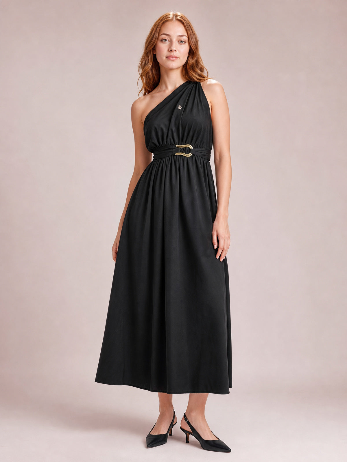Model poses in a black single shoulder midi dress with gathered bodice, defined waist, ring-detail belt, and flowing A-line skirt.