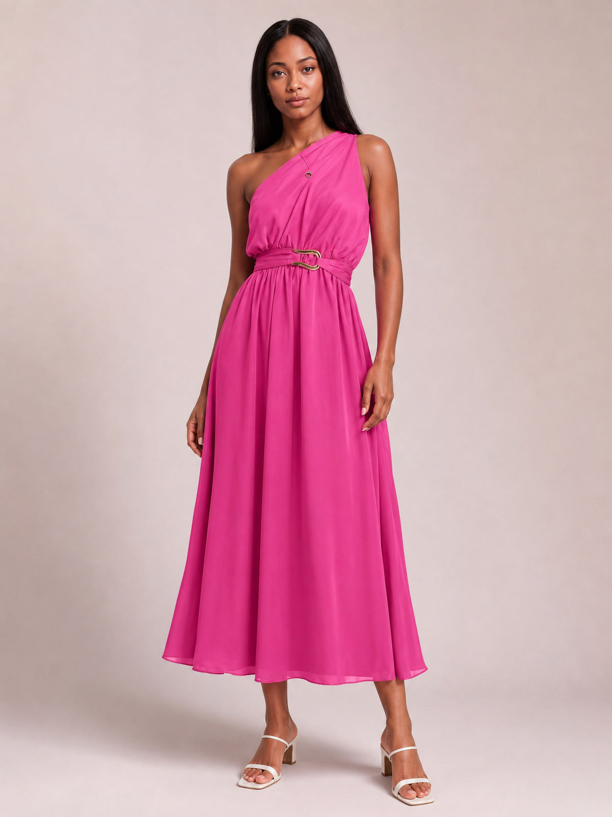 Model poses in a vibrant pink single shoulder midi dress with a softly gathered bodice, defined waist, ring-detail belt, and flowing A-line skirt.