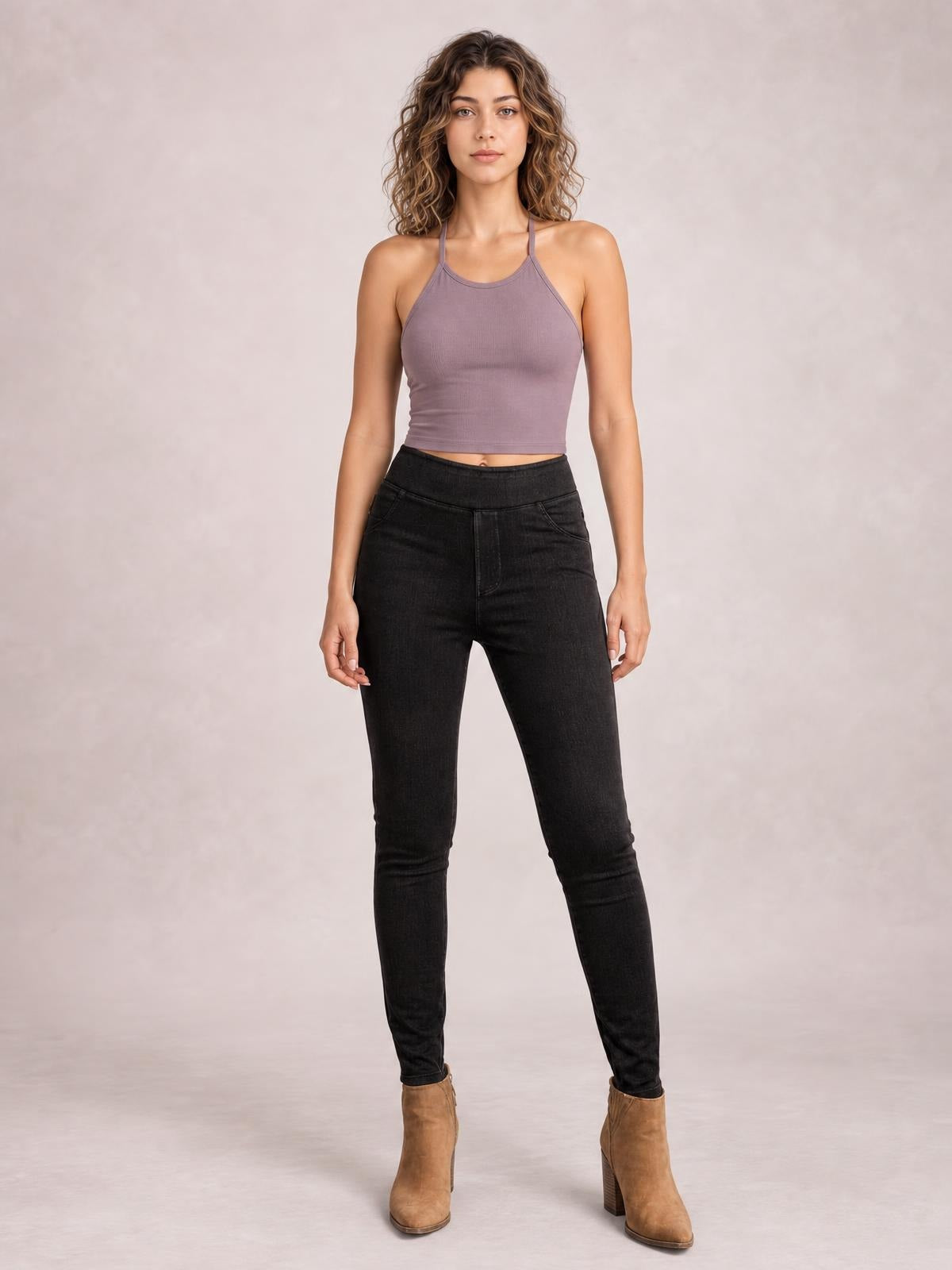 Model stands facing forward in black skinny jeans with visible front pockets, a high-rise waistband, fitted silhouette, and close-fitting legs.