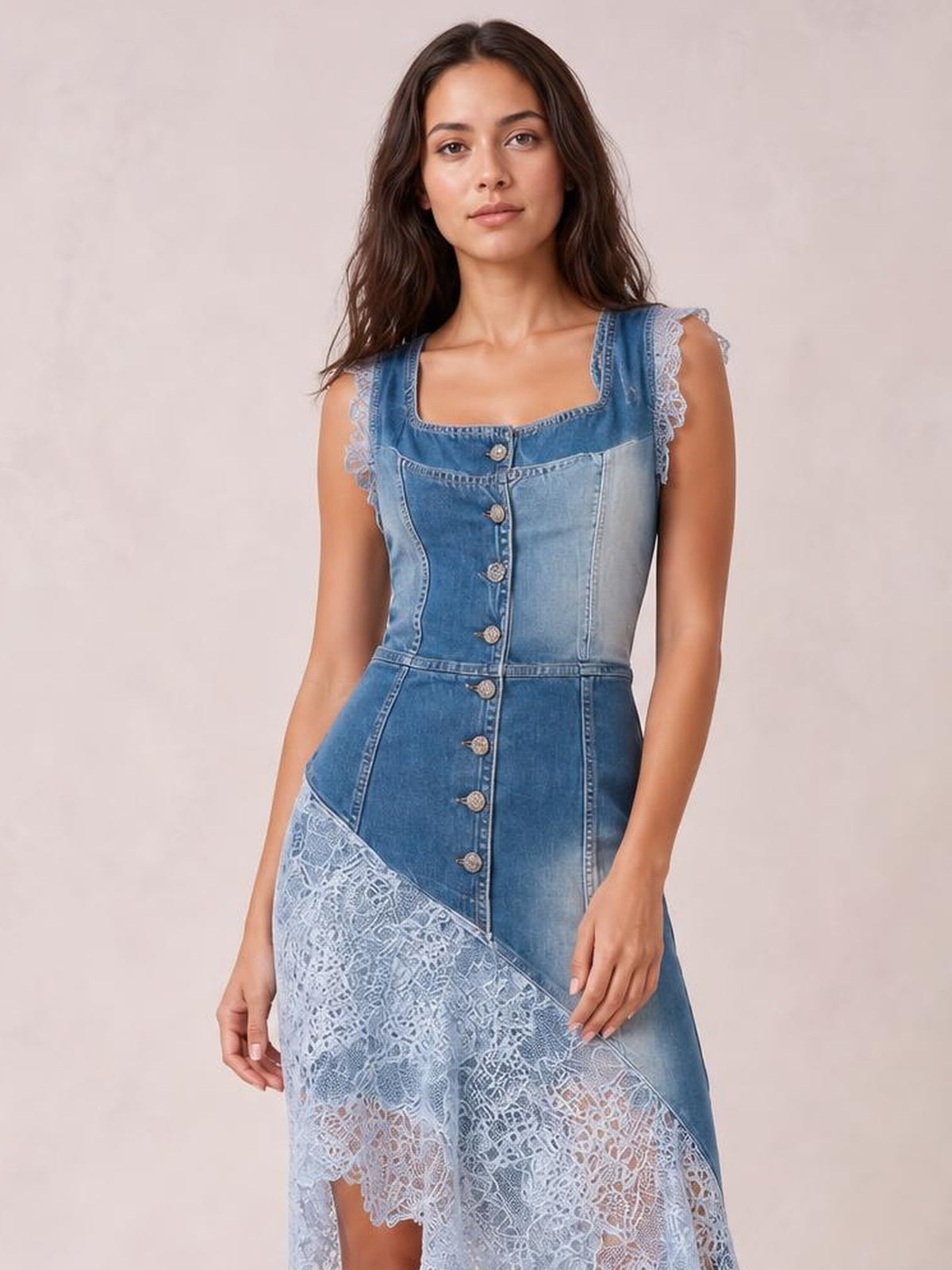 Model poses in a blue sleeveless patchwork denim dress with a square neckline, front buttons, fitted waist, and asymmetric lace hem.