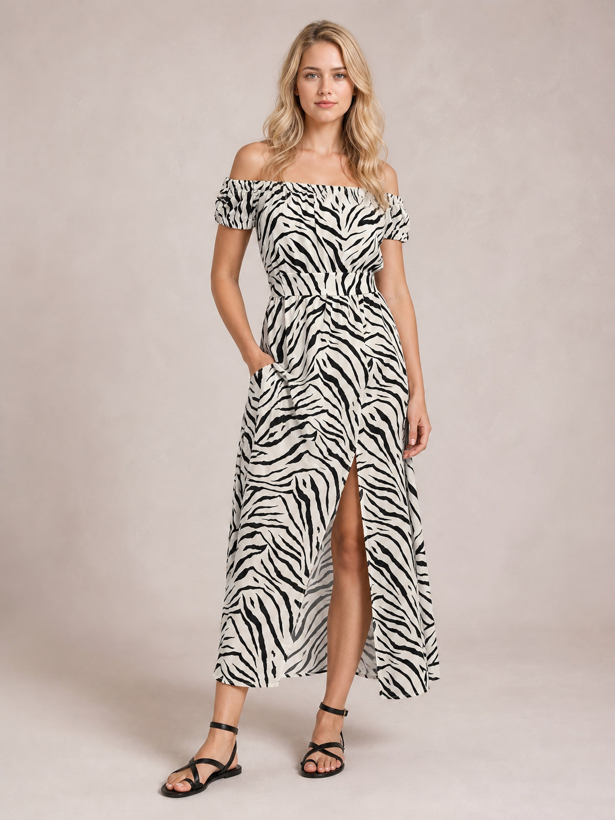 A model wears a white and black zebra-print off-shoulder midi dress with short sleeves, a defined waist, flowing skirt, and front slit.