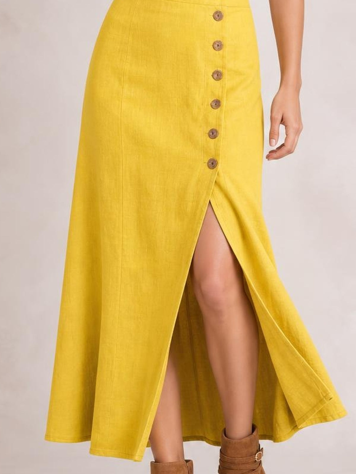A model stands in a bright yellow midi dress with a front button row, flowing A-line silhouette, and high front slit revealing one leg.