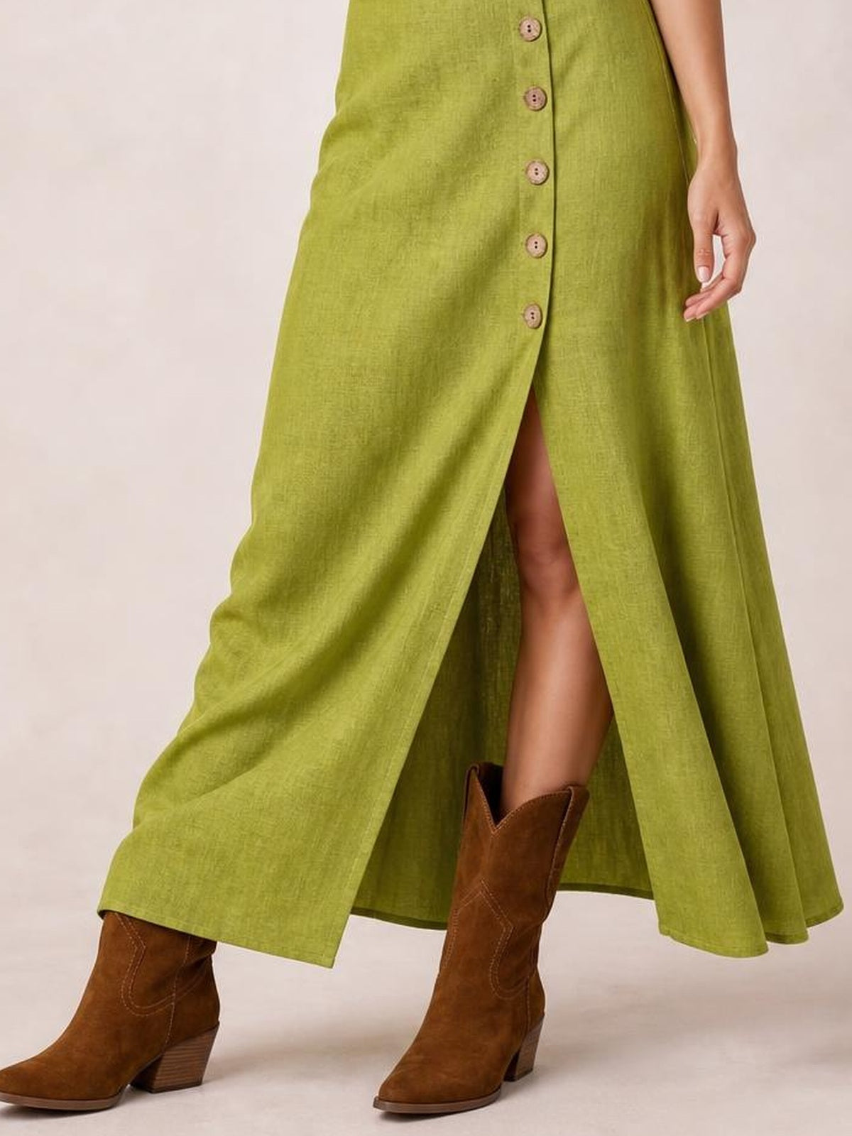 Model wears a lime green button-down midi dress with a flowing A-line silhouette, front slit, and softly textured construction.