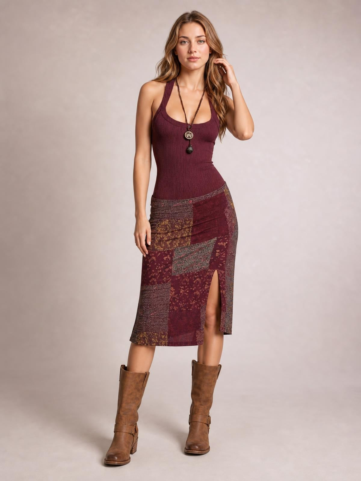 Model poses in a fitted burgundy printed sleeveless midi dress with a ribbed scoop-neck bodice, body-hugging silhouette, and side slit.