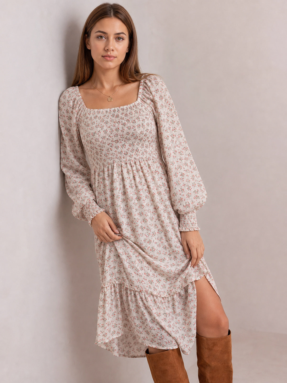 Model poses in a pale floral midi dress with a square neckline, smocked bodice, long puff sleeves, gathered waist, and tiered flounced hem.